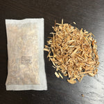 Woodcycle natural tea bag firelighter and loose on a dark surface