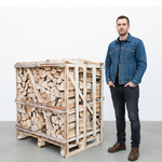 Man standing next to a large wooden crate filled with firewood on a white background